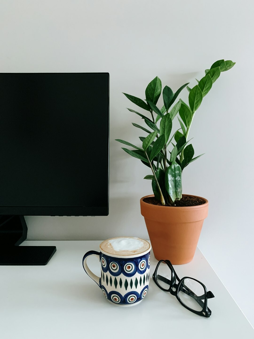 Minimalist office desk with notebook and plant